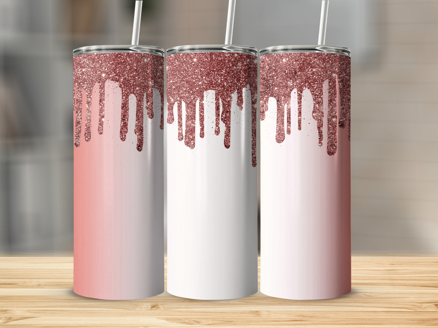 Three tumblers with rose gold glitter drips on a light wood surface.