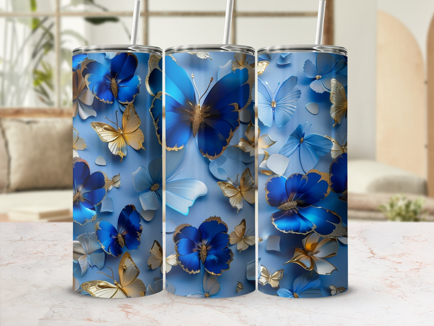 Three blue tumblers with gold and blue butterfly and floral designs.