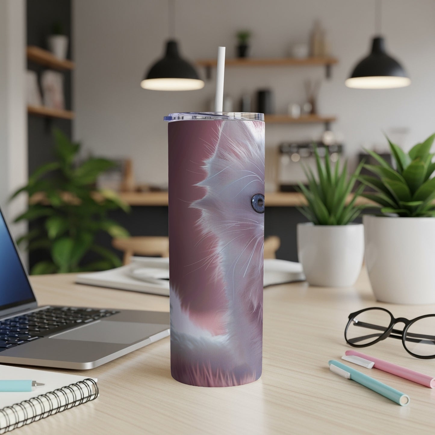 White cat face design on a tall, pink tumbler with a straw.