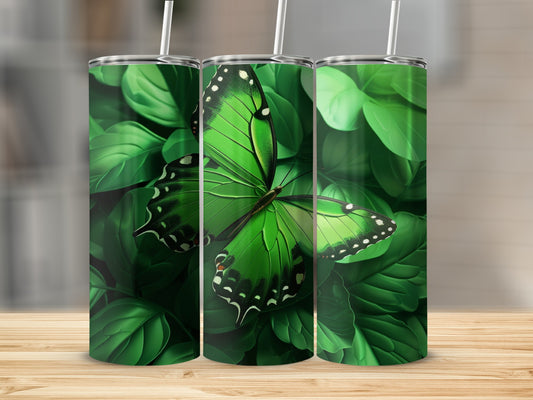 Three tumblers with a vibrant green butterfly on a backdrop of lush green leaves.