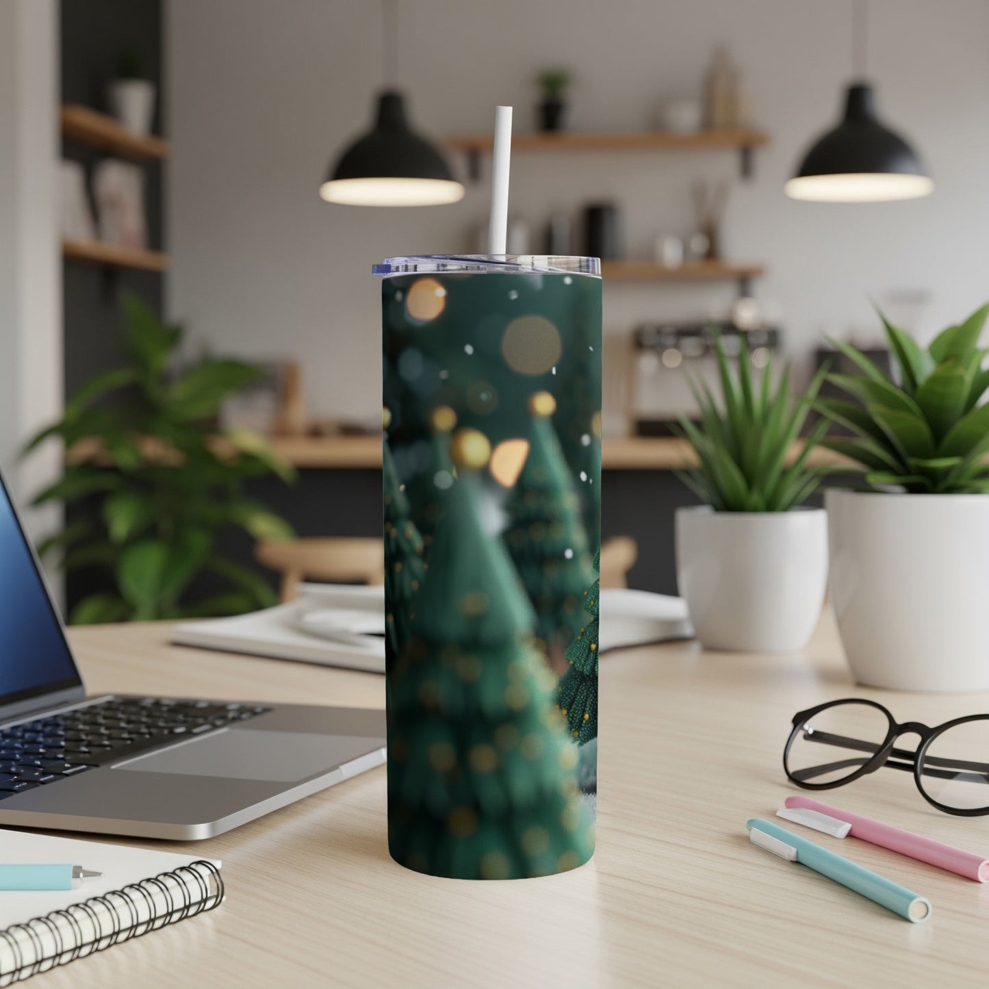Christmas tree tumbler with bokeh lights on desk.