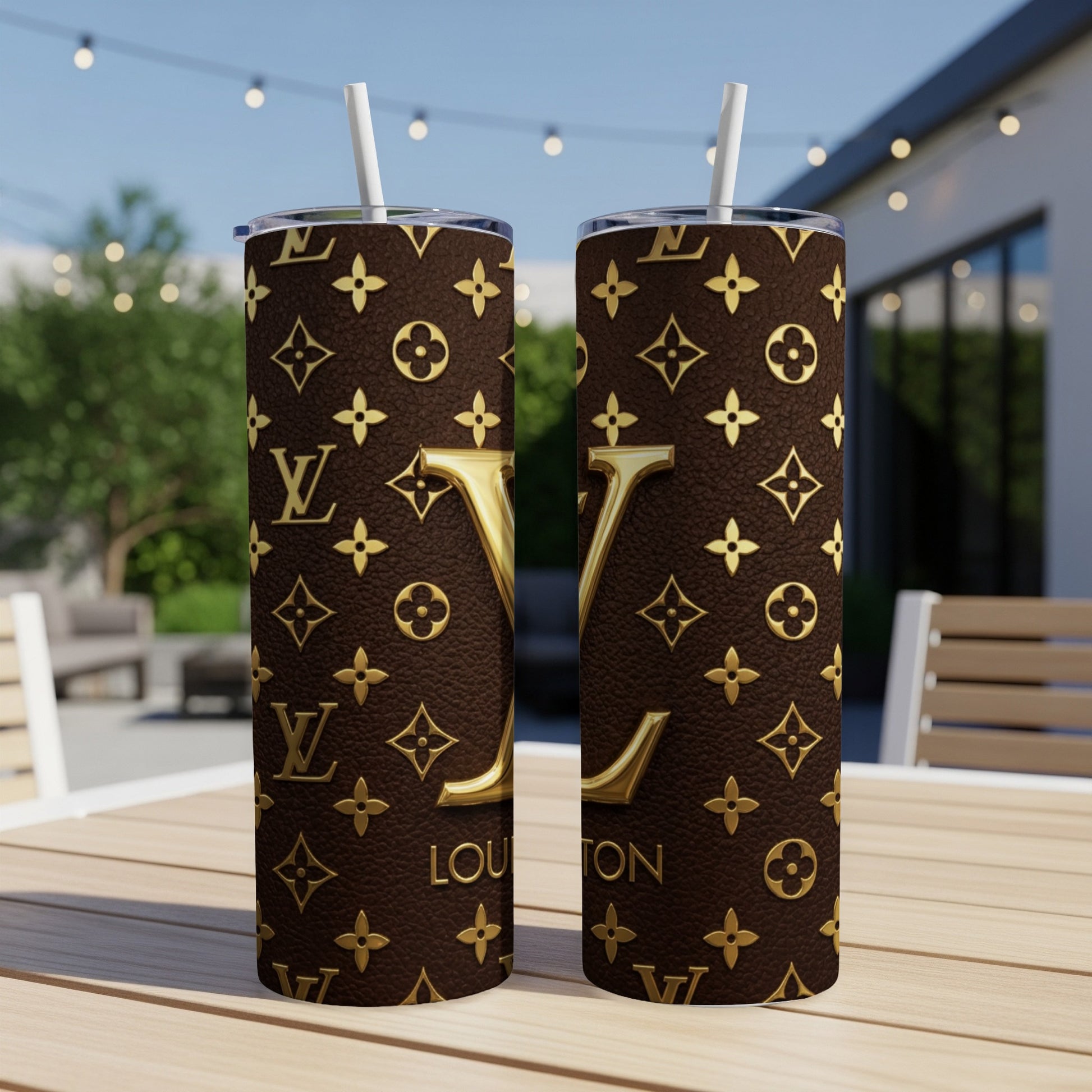 Two tumblers with brown leather pattern and gold LV monogram, on a table.