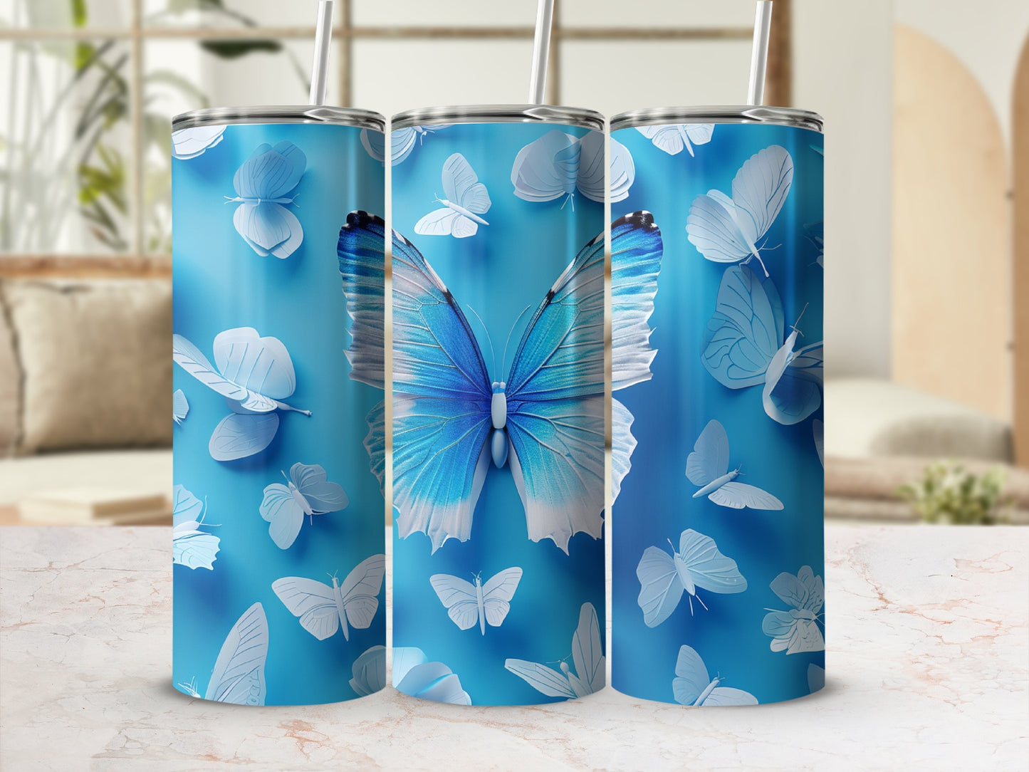 Three blue tumblers with butterfly designs, featuring a large blue butterfly.