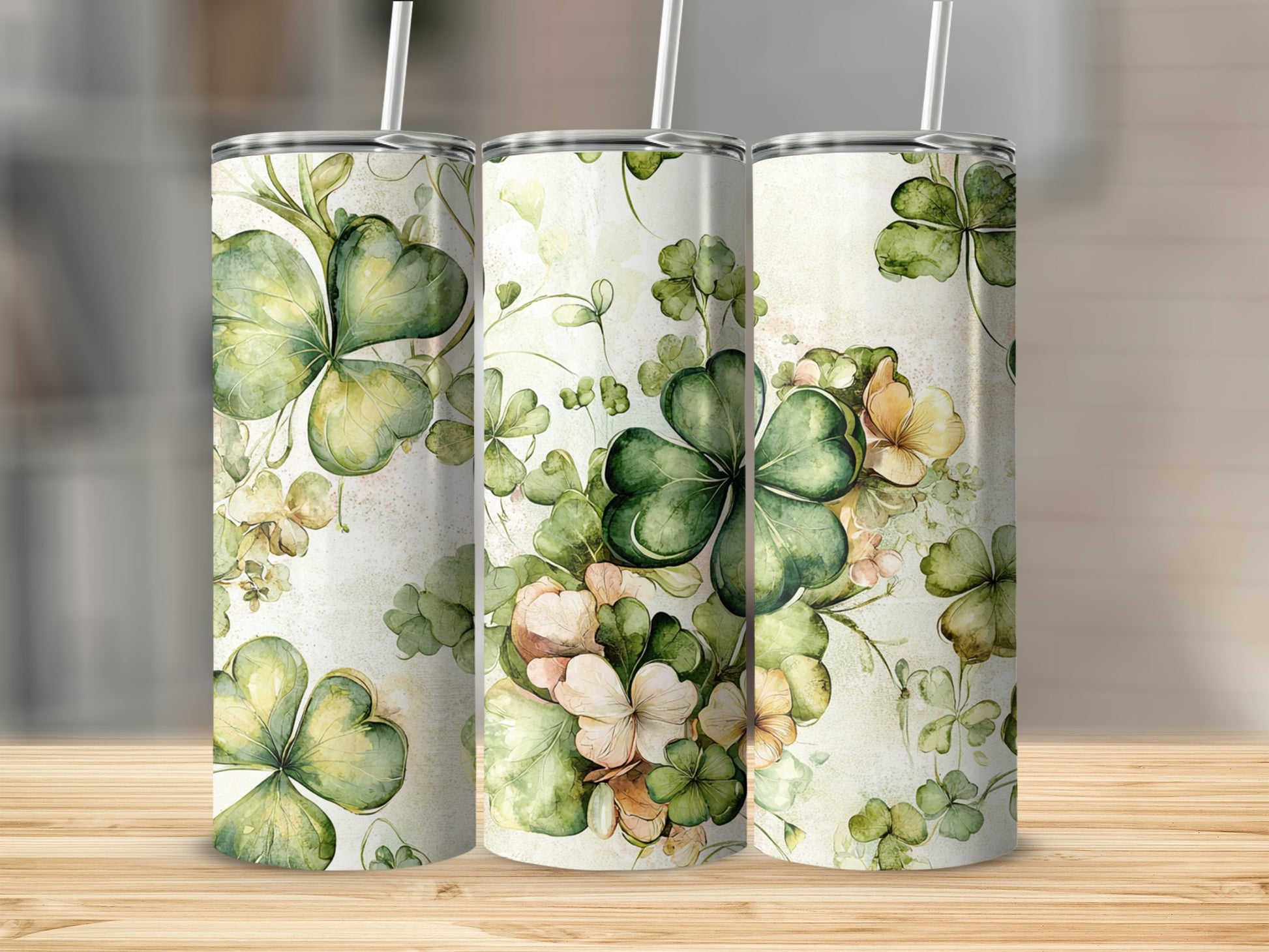 Three tumblers decorated with shamrocks and floral watercolor patterns.