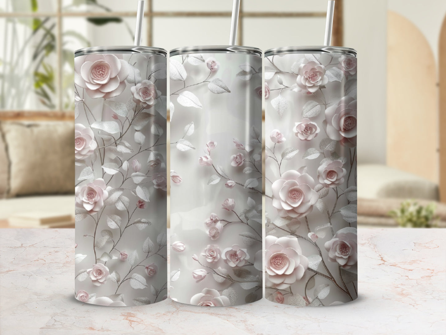 Three tumblers with a pink floral and vine design on a marbled surface.