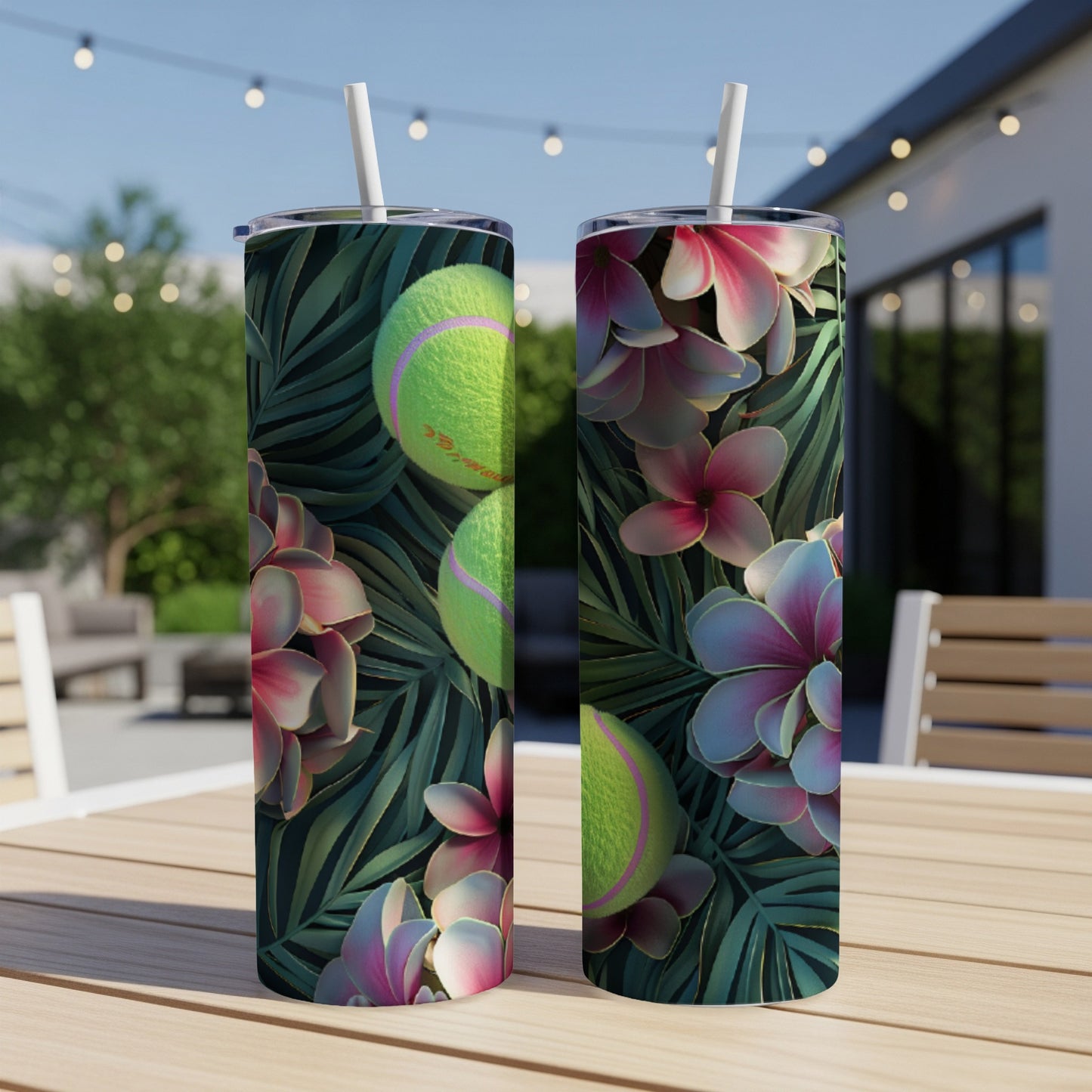 Two tumblers with tennis balls and tropical flowers on a wooden table.