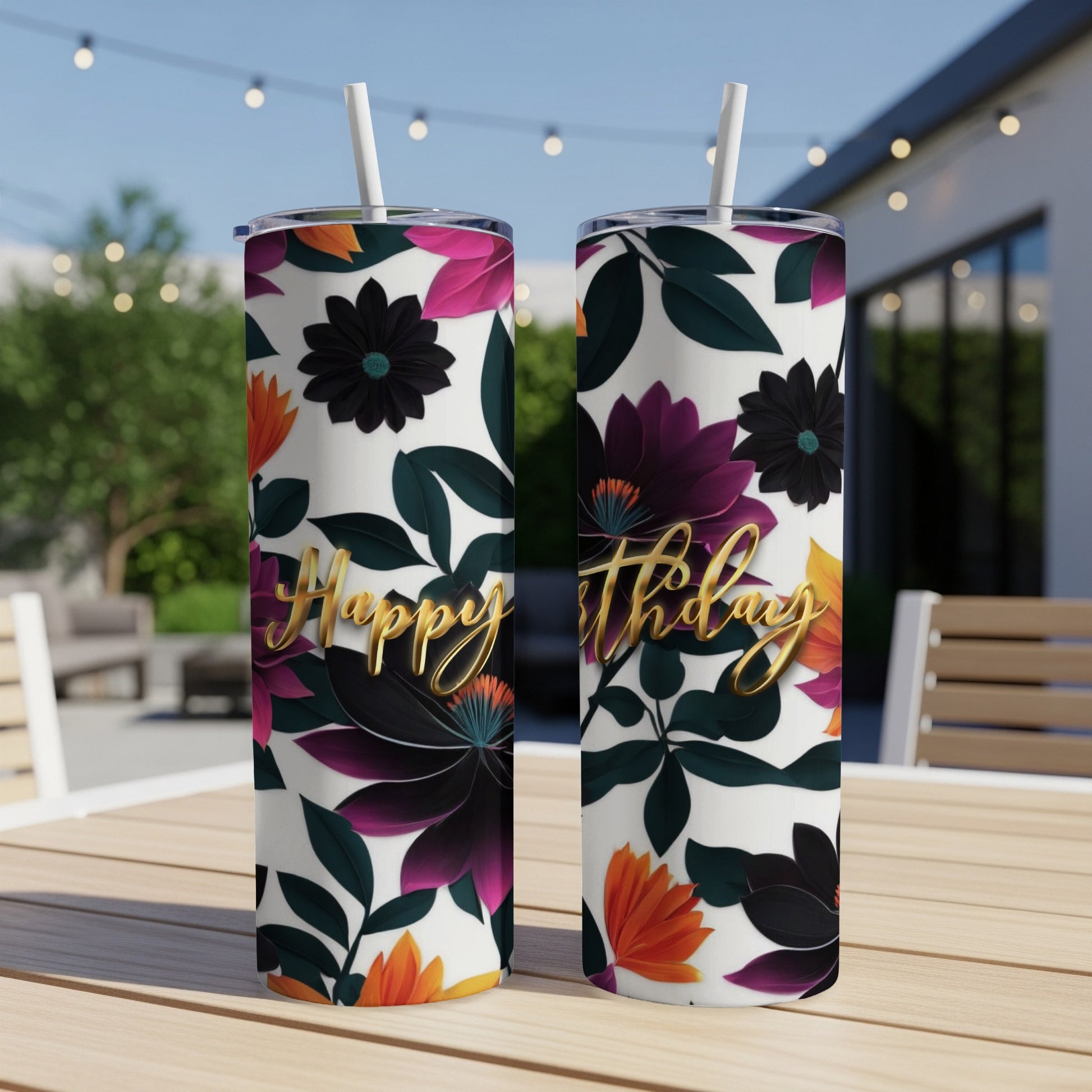Two tumblers with "Happy Birthday" text and floral design on a table.