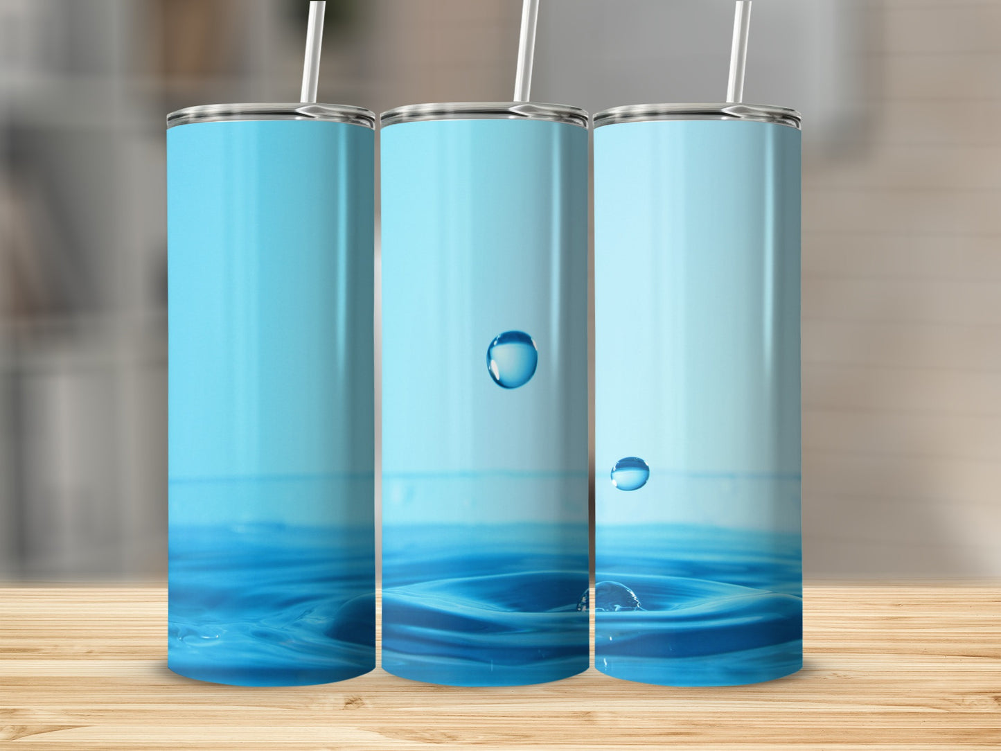 Three blue tumblers with water droplet graphics on a wooden surface.