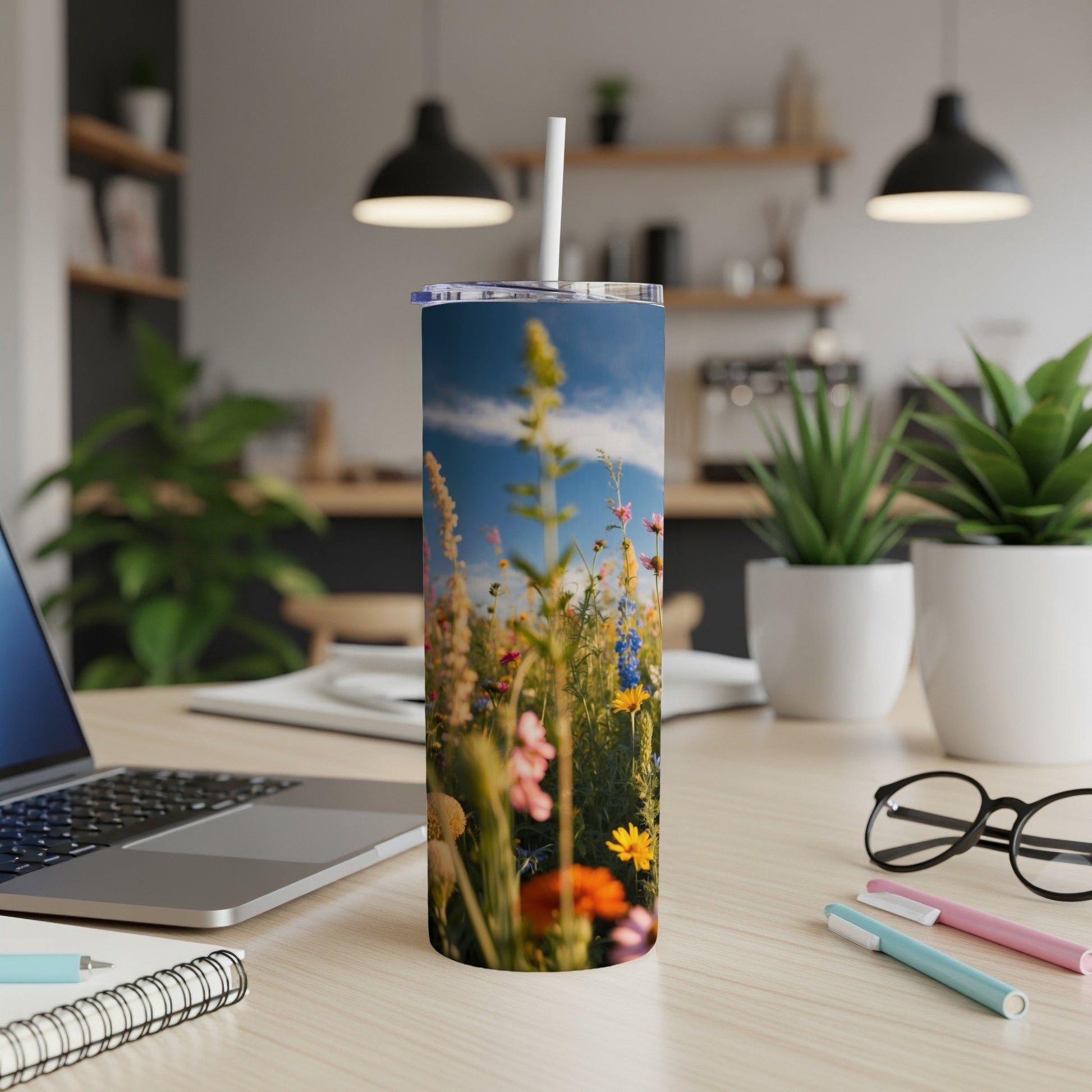 Tall tumbler with colorful wildflowers and blue sky.