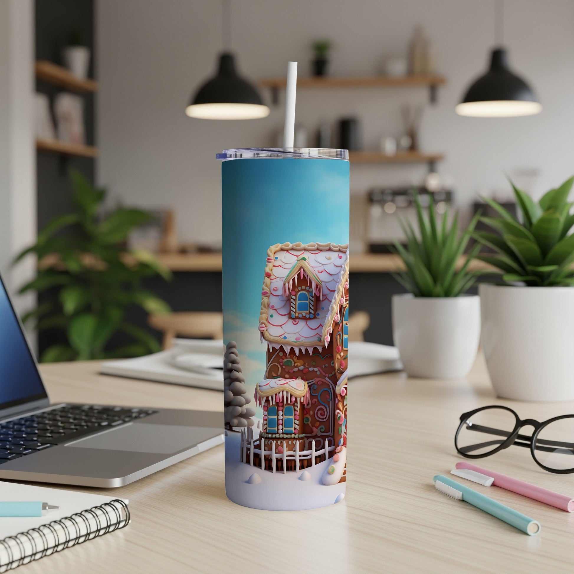 Gingerbread house tumbler with straw on desk.