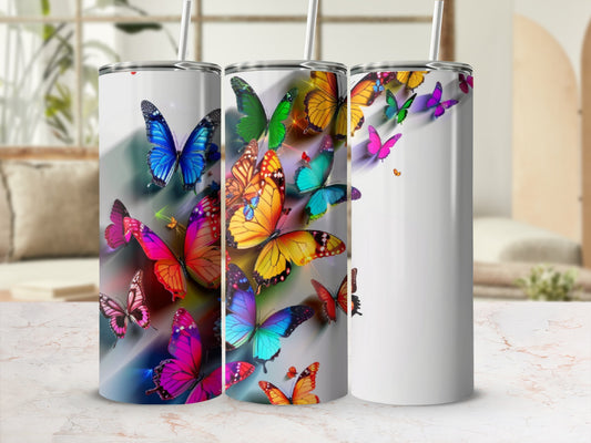 Three tumblers adorned with colorful, vibrant butterflies on a white background.