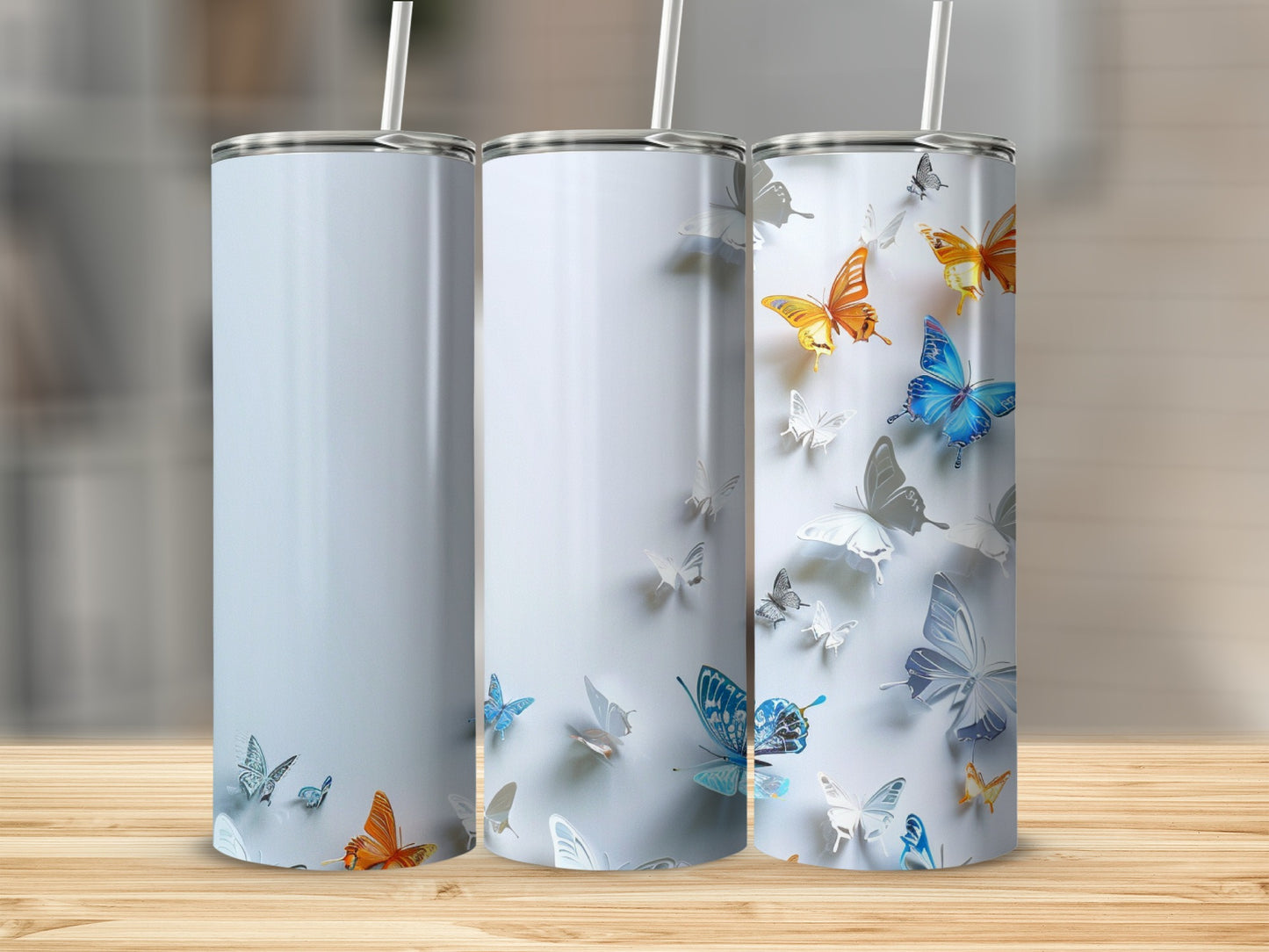Three white tumblers with colorful butterflies and white text on a wooden surface.