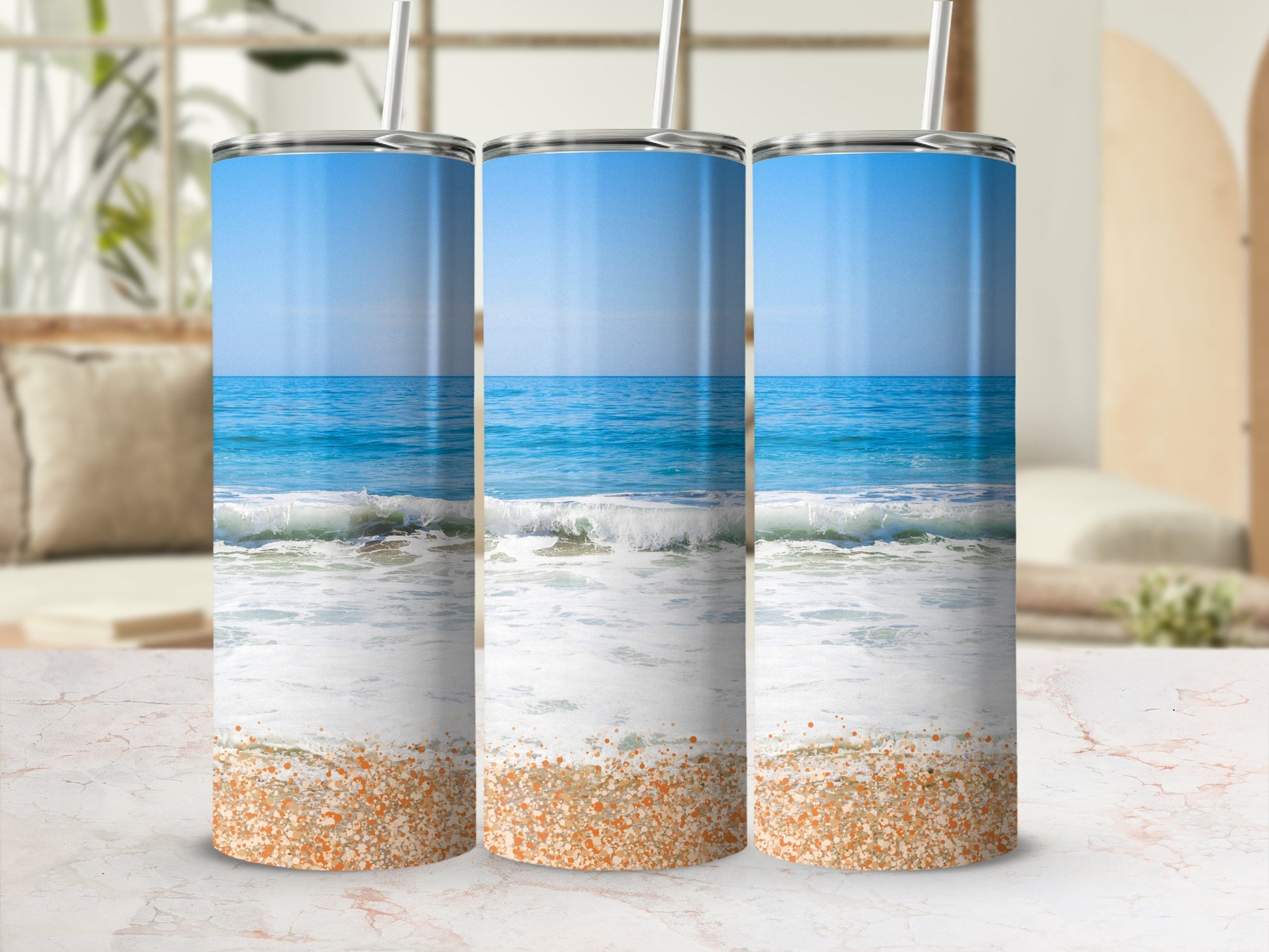 Three tumblers featuring a beach scene with ocean waves and sand.