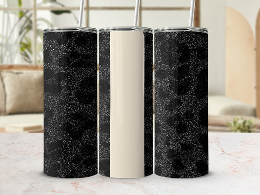 Three insulated tumblers with speckled black and cream designs on a marble surface.