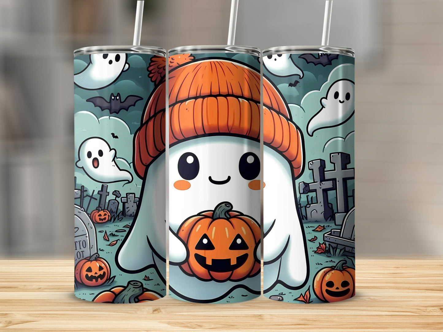 Three tumblers decorated with a cartoon ghost holding a pumpkin and Halloween graveyard scene.