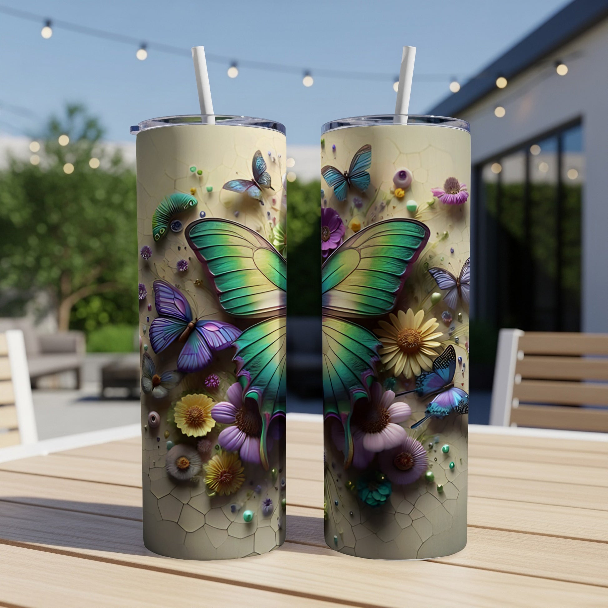 Two tumblers with butterflies and flowers on a table outdoors.