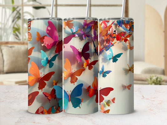 Three tumblers featuring vibrant, colorful butterfly designs and floral patterns.