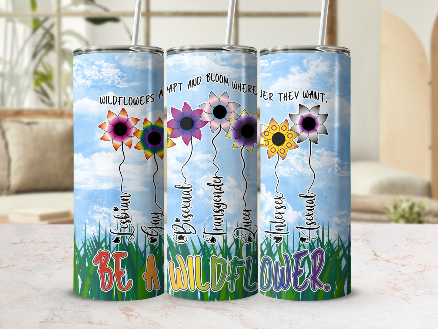 Tumbler with flowers representing LGBTQ+ identities and the phrase "Be a wildflower."