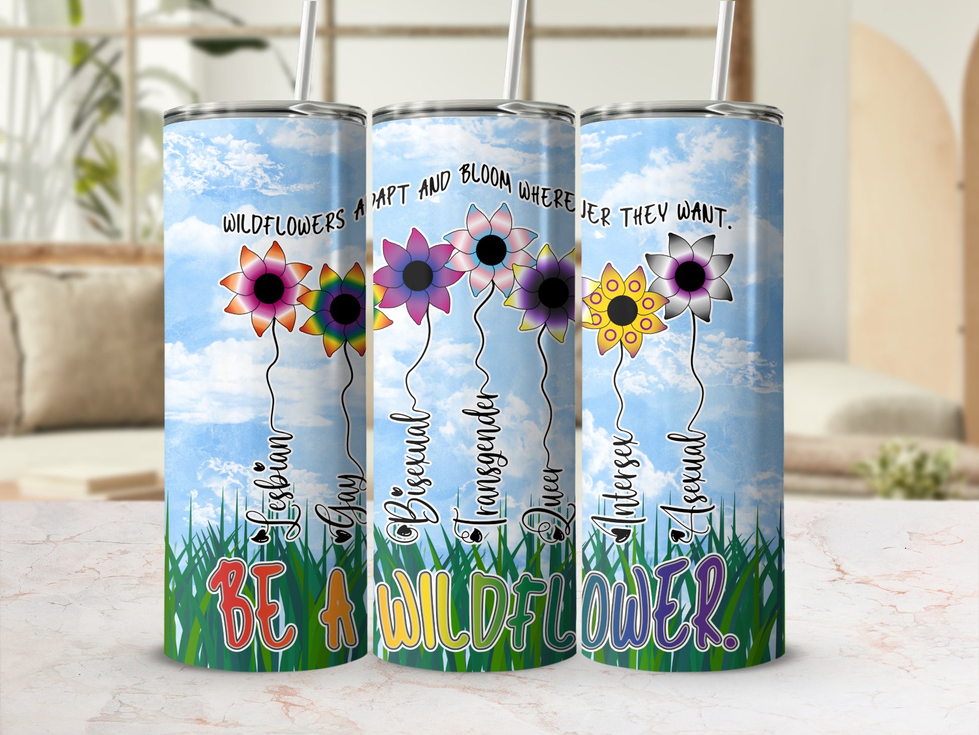 Tumbler with flowers representing LGBTQ+ identities and the phrase "Be a wildflower."