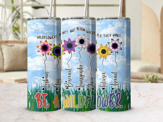 Tumbler with flowers representing LGBTQ+ identities and the phrase "Be a wildflower."