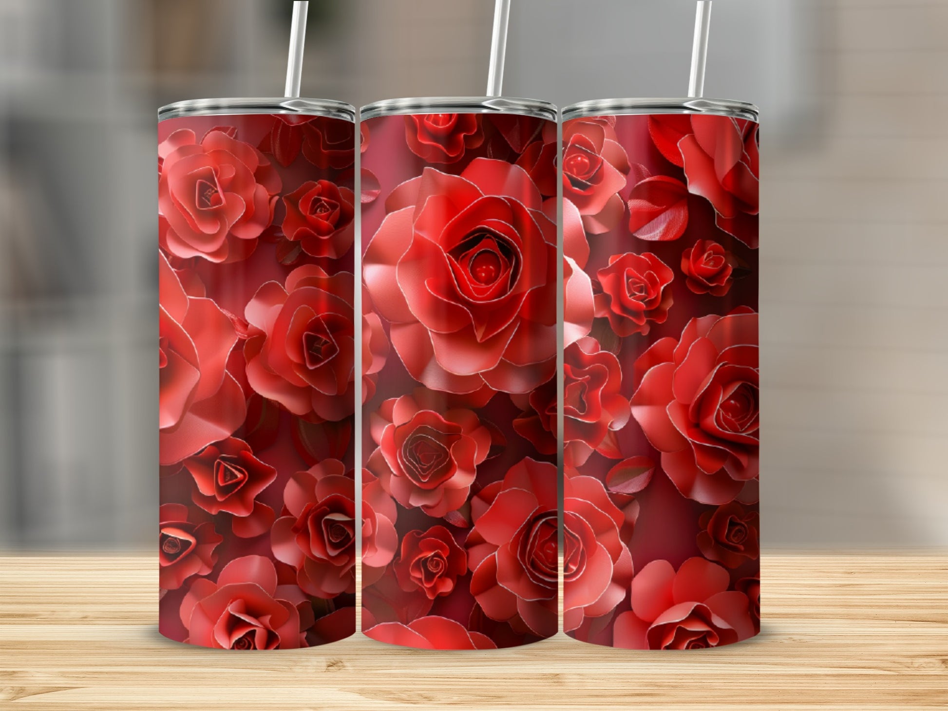 Three tumblers with red rose floral pattern on a wooden surface.