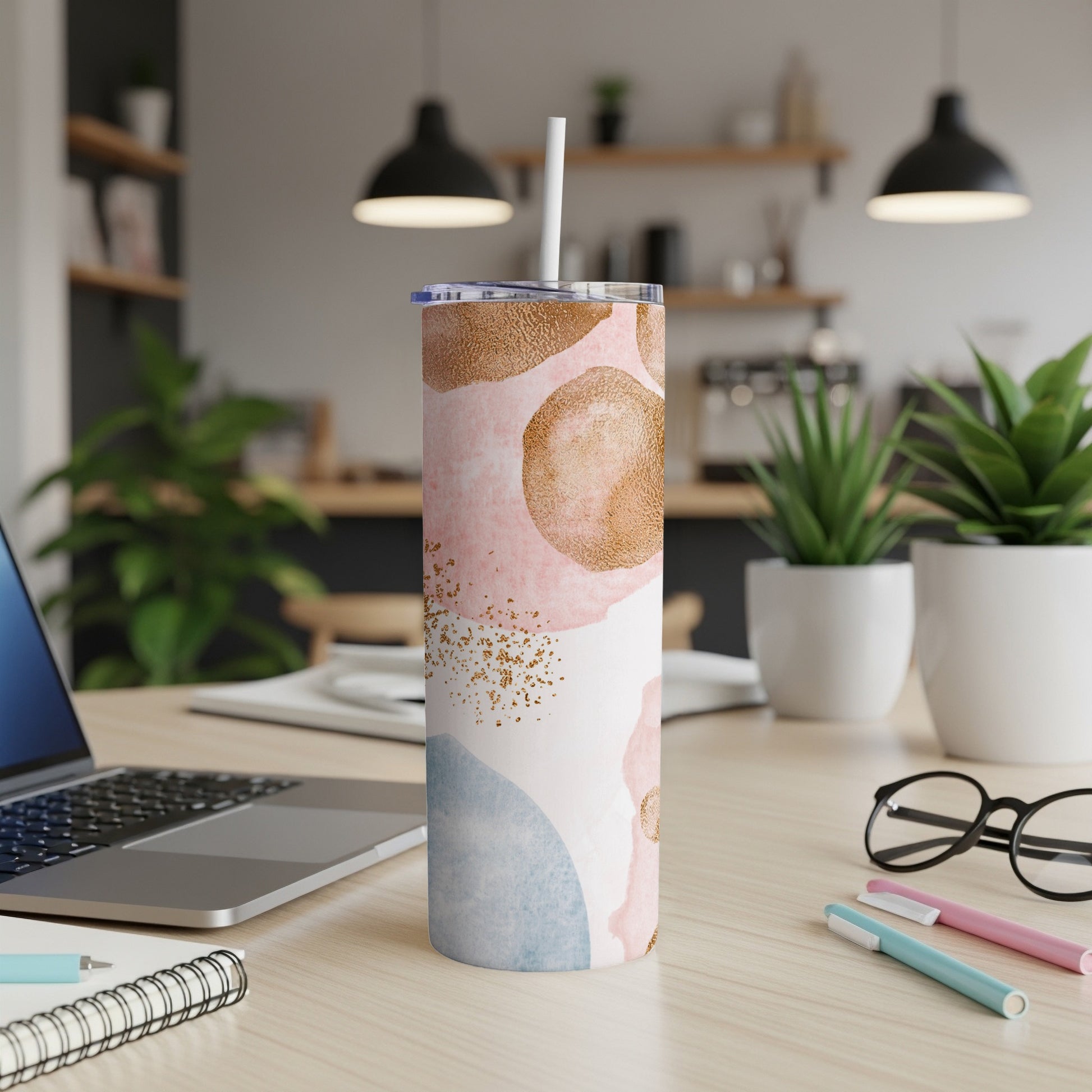 Tall tumbler with pink, blue, and gold abstract pattern.