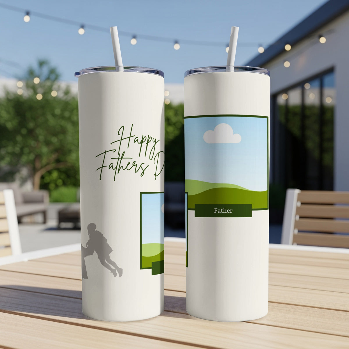 Two white tumblers with straw on a wooden table, one with "Happy Fathers Day" and silhouette.