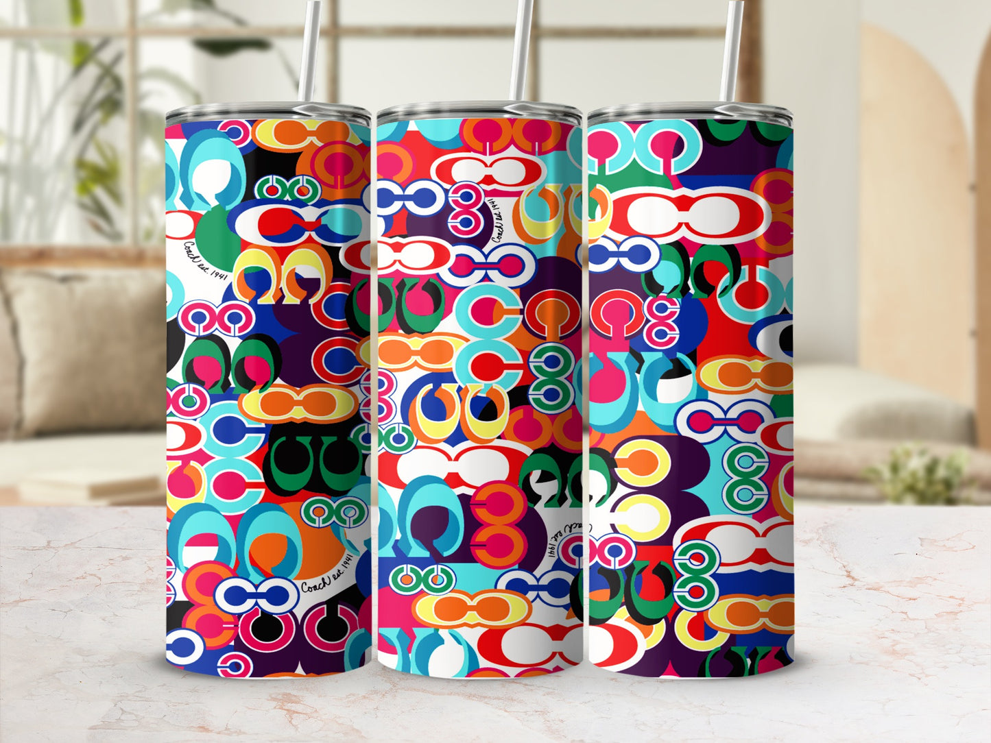 Three tumblers with a colorful geometric pattern and "Coach est. 1941" text.