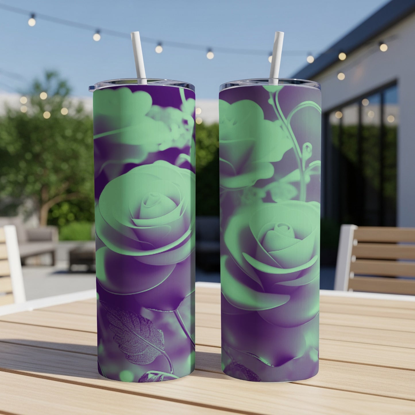 Two tumblers with purple and green rose floral design on a table outdoors.