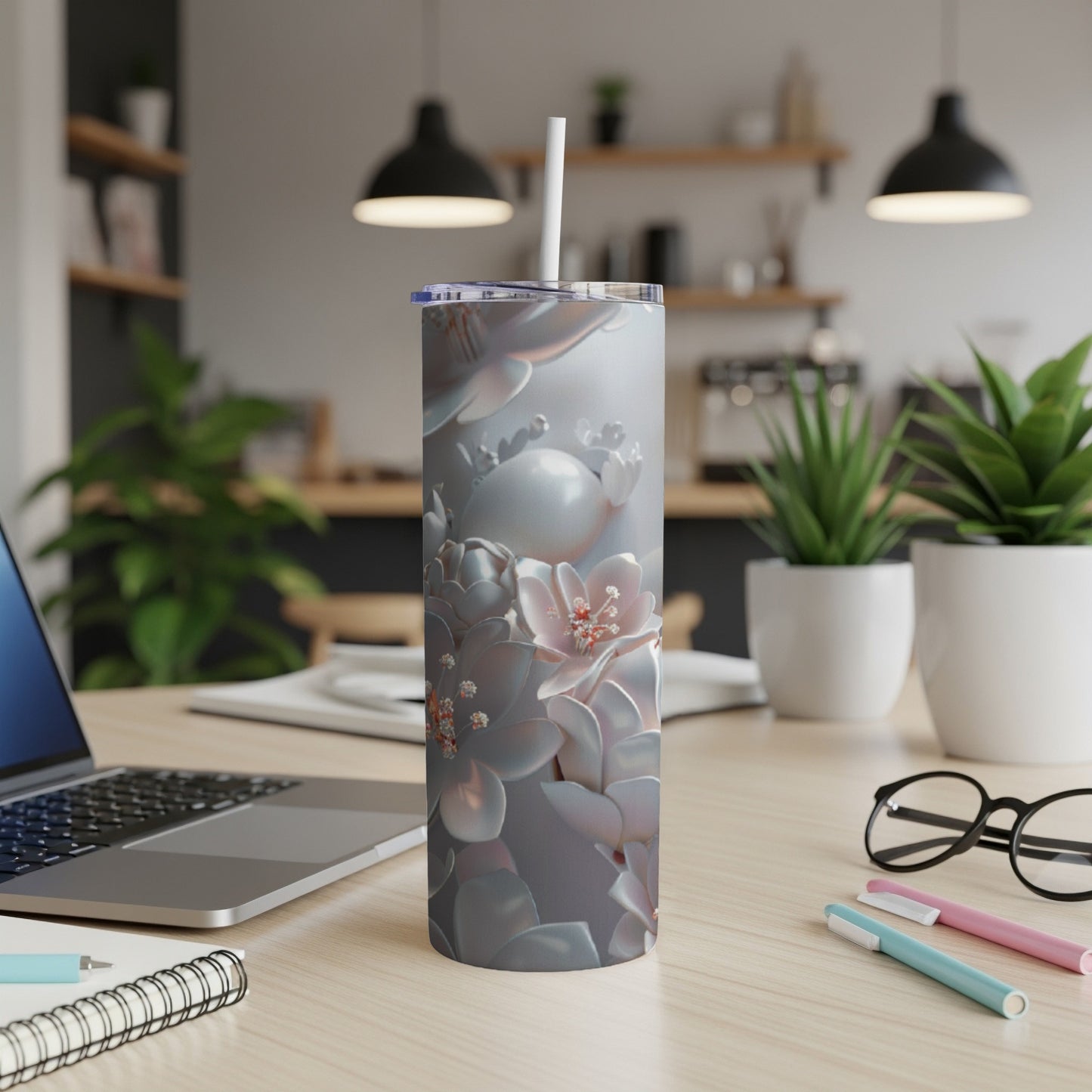 Floral pattern stainless steel tumbler with lid and straw on a desk.