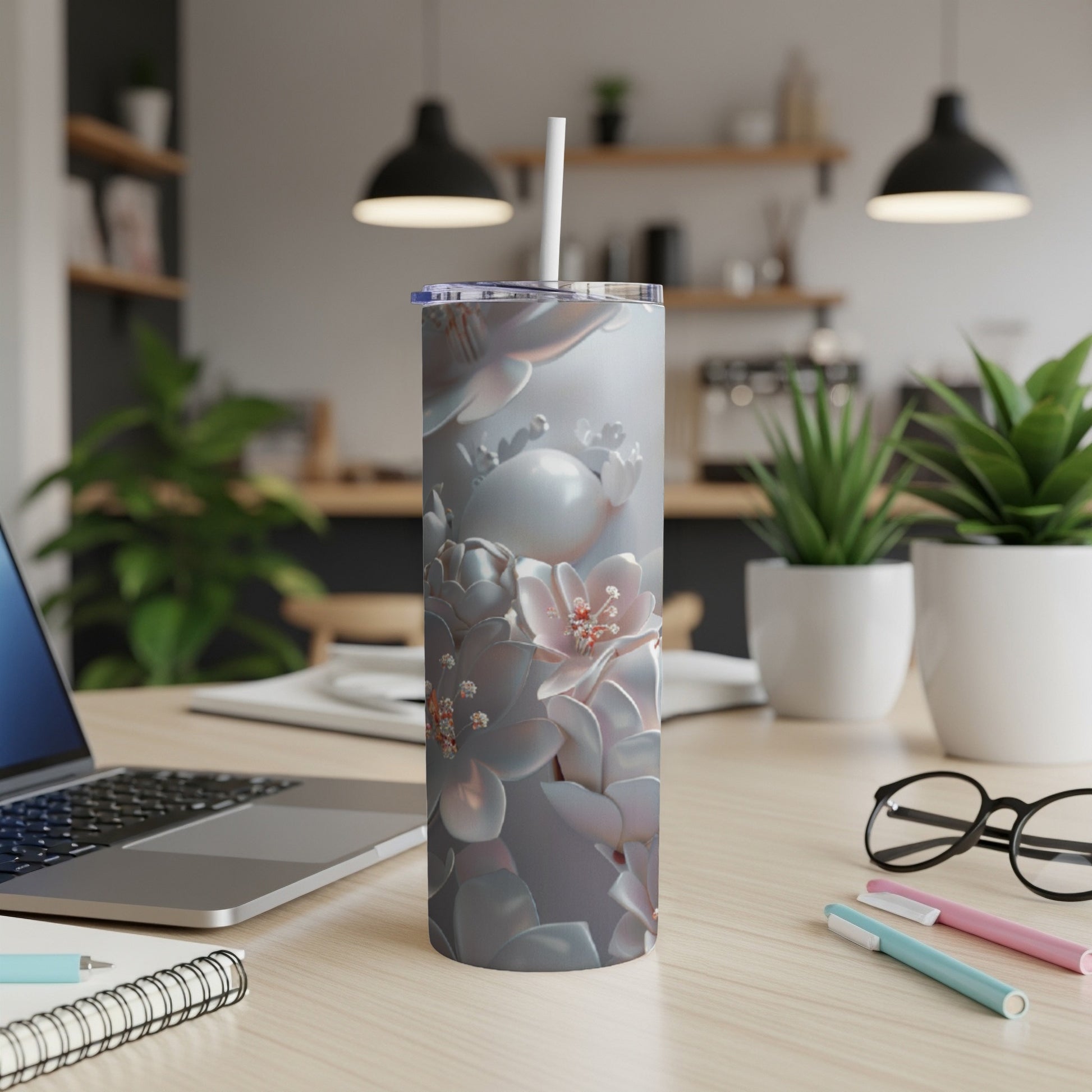Floral pattern stainless steel tumbler with lid and straw on a desk.
