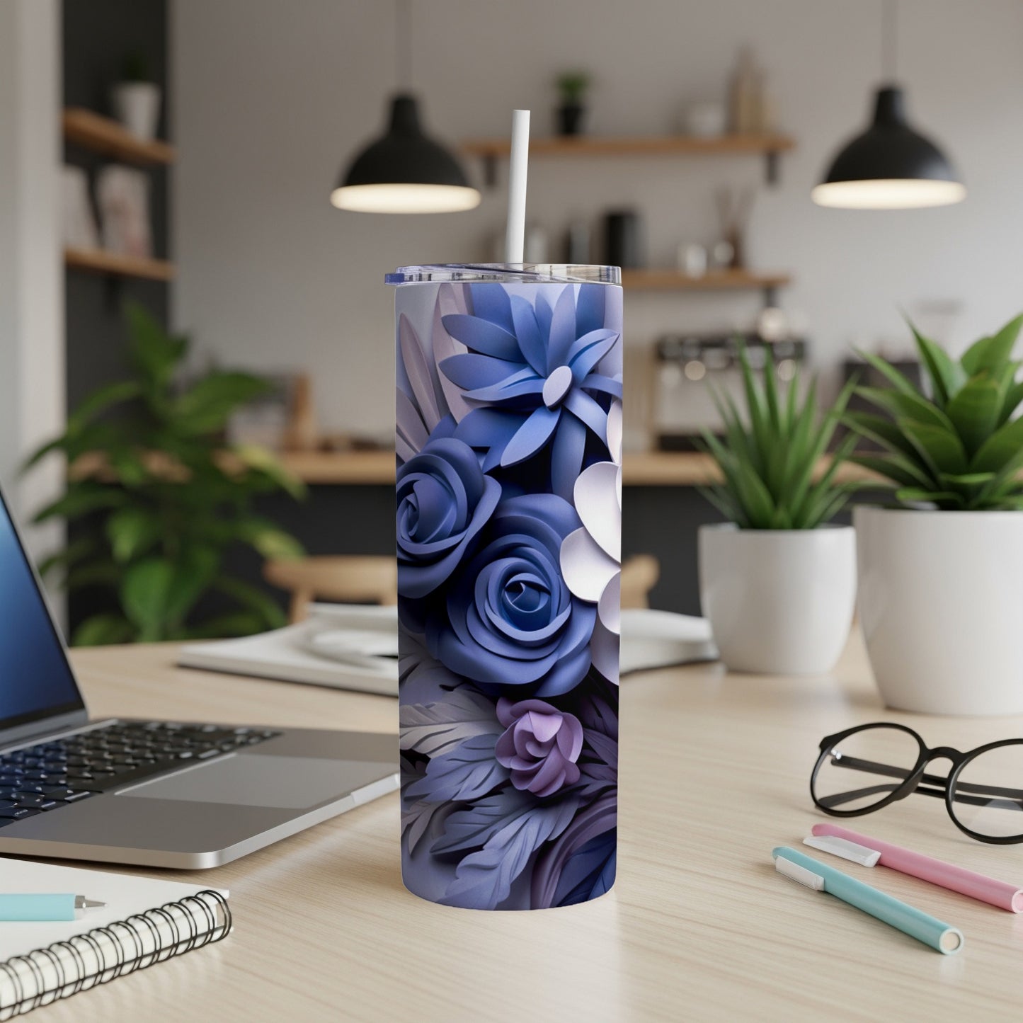 Purple floral tumbler with straw on a desk next to a laptop.