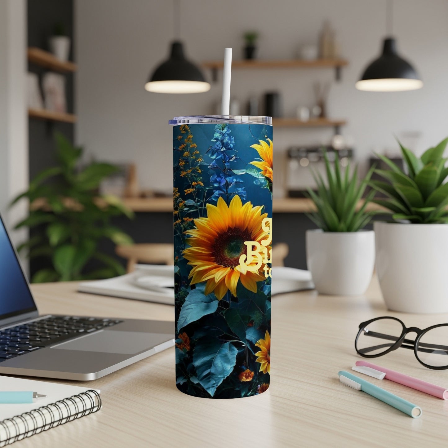 Sunflower design on a tall, skinny tumbler on a desk.