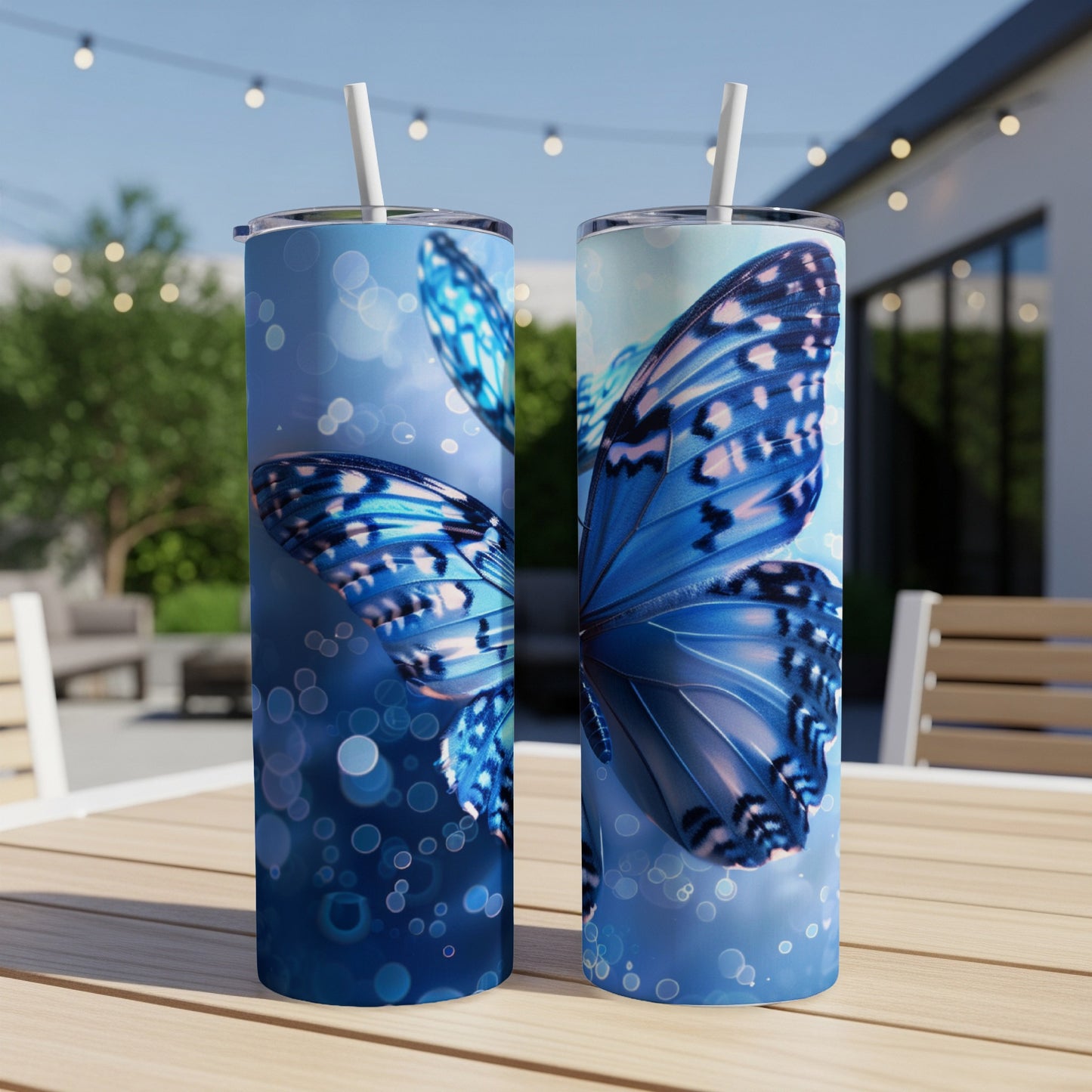Two blue butterfly tumblers on a table with bokeh lights.