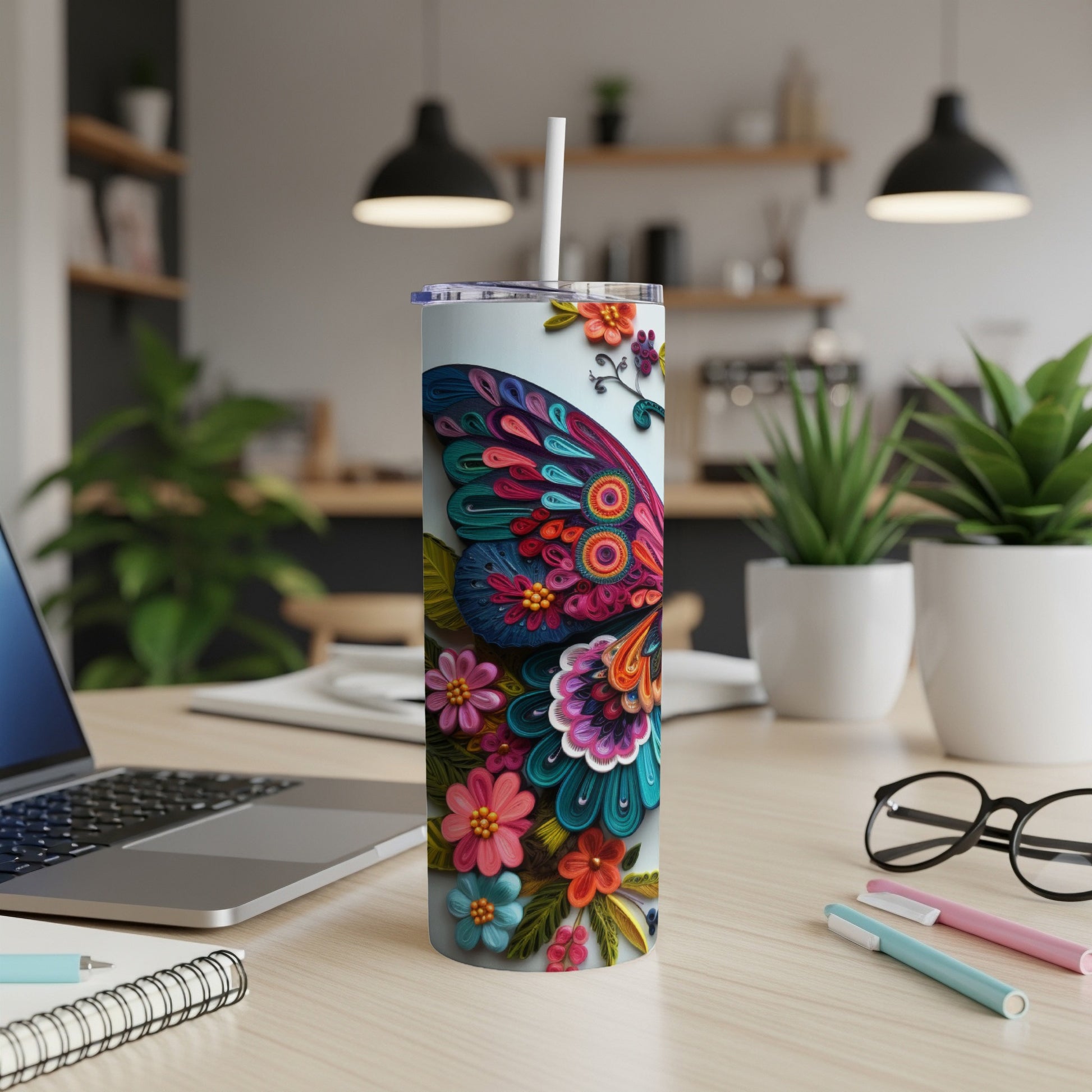 Tumbler with colorful floral butterfly design on a desk.