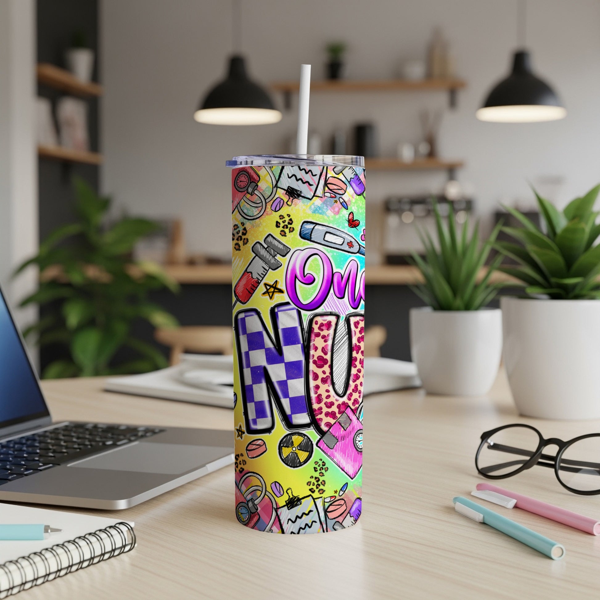 Colorful "On N U" tumbler with medical and playful graphics on a desk.