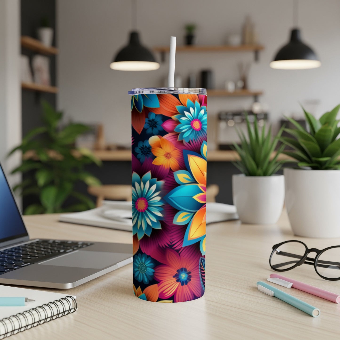 Colorful floral patterned tumbler with a straw on a desk.