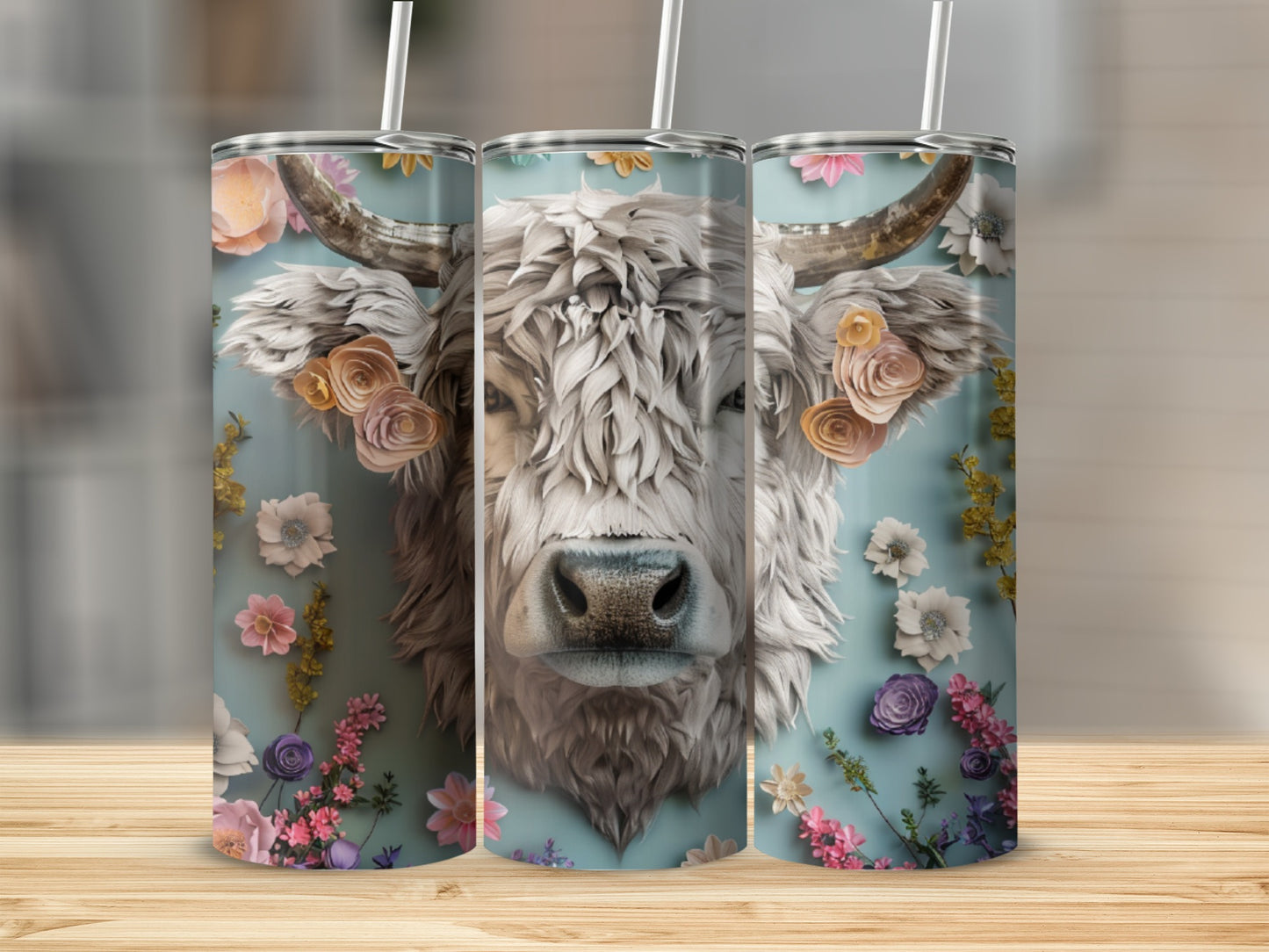 White cow face with floral accents on a blue background, printed on three tumblers.