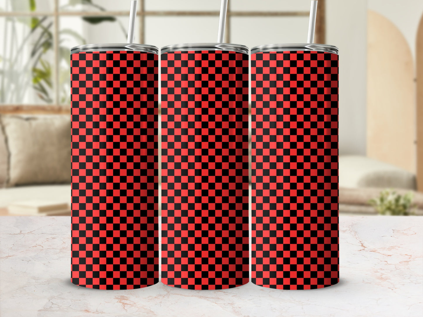Three red and black checkered tumblers with straws on a marble surface.