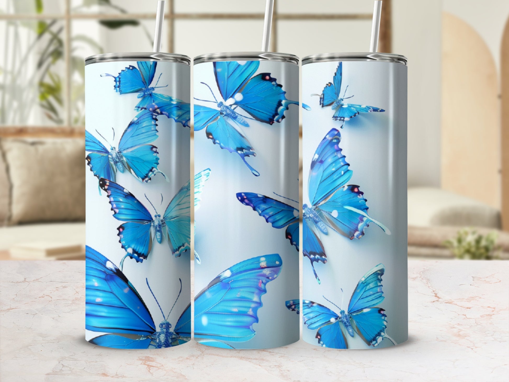 Blue butterflies on a white tumbler with straws and straw lids.