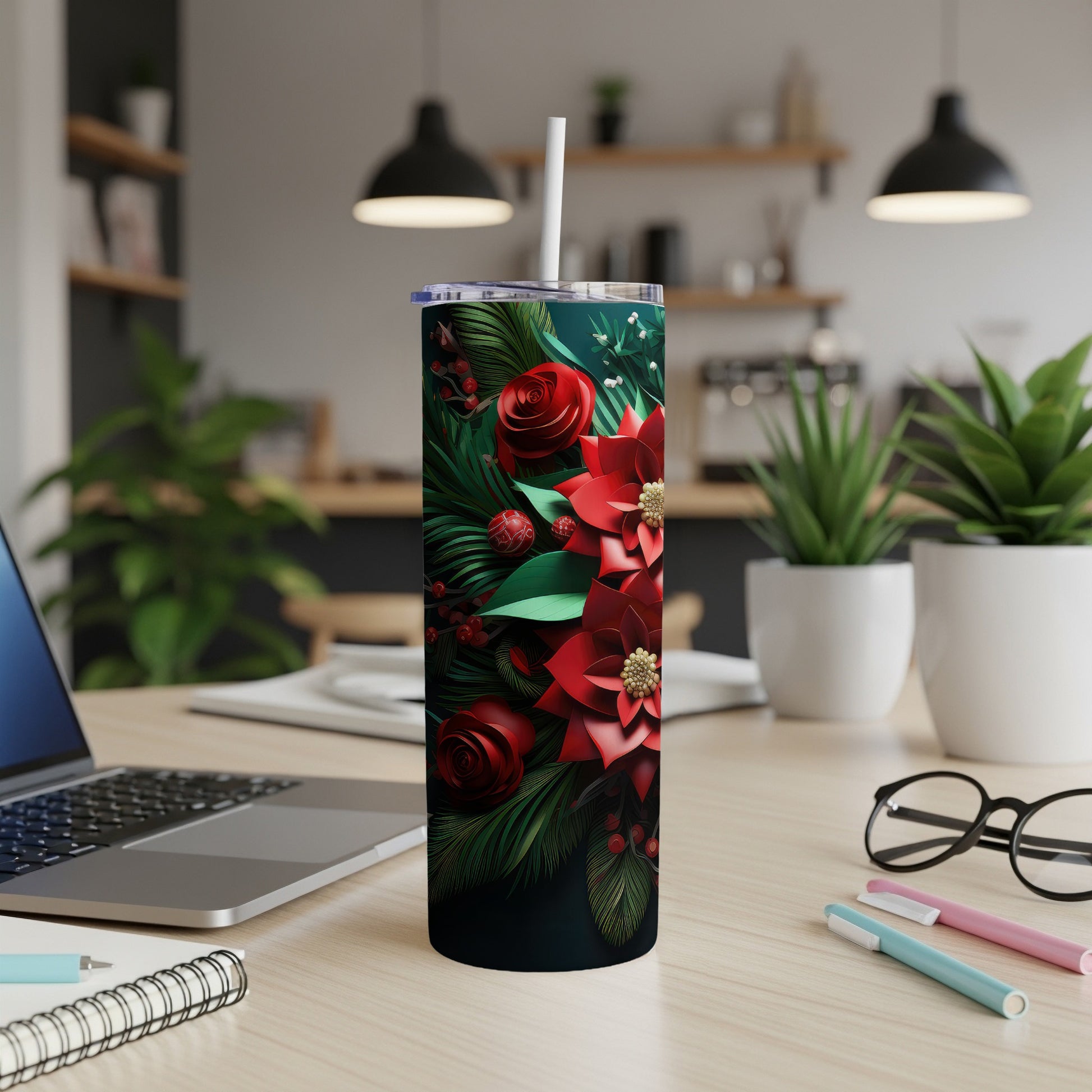 Floral tumbler with poinsettias and roses on a wooden desk.