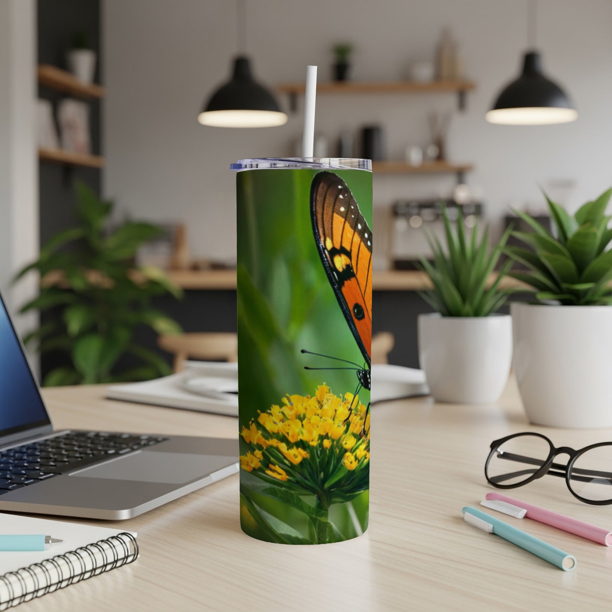 Orange and black monarch butterfly on yellow flower, on a tumbler.
