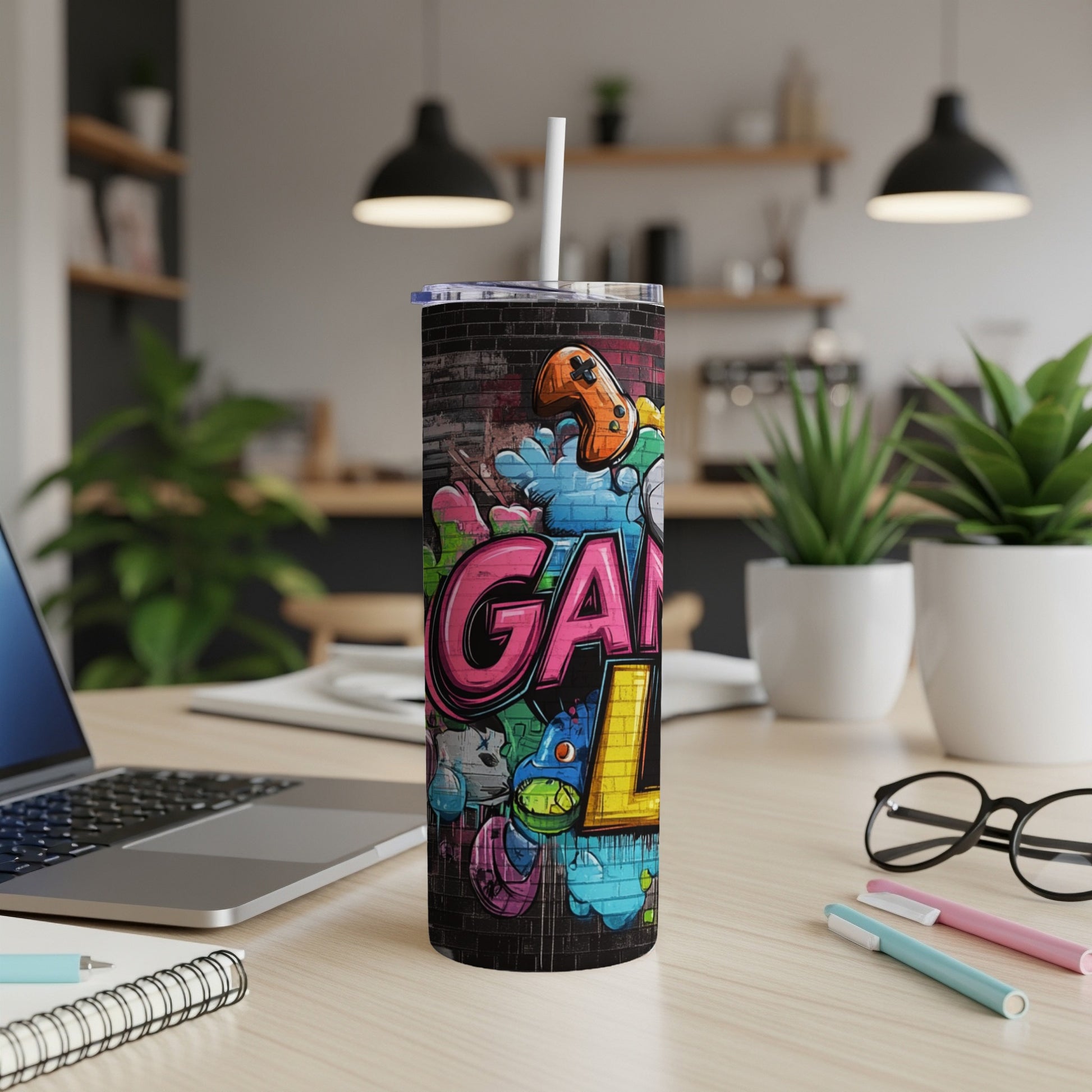Graffiti art "GAMING" on a skinny tumbler with colorful gaming icons.