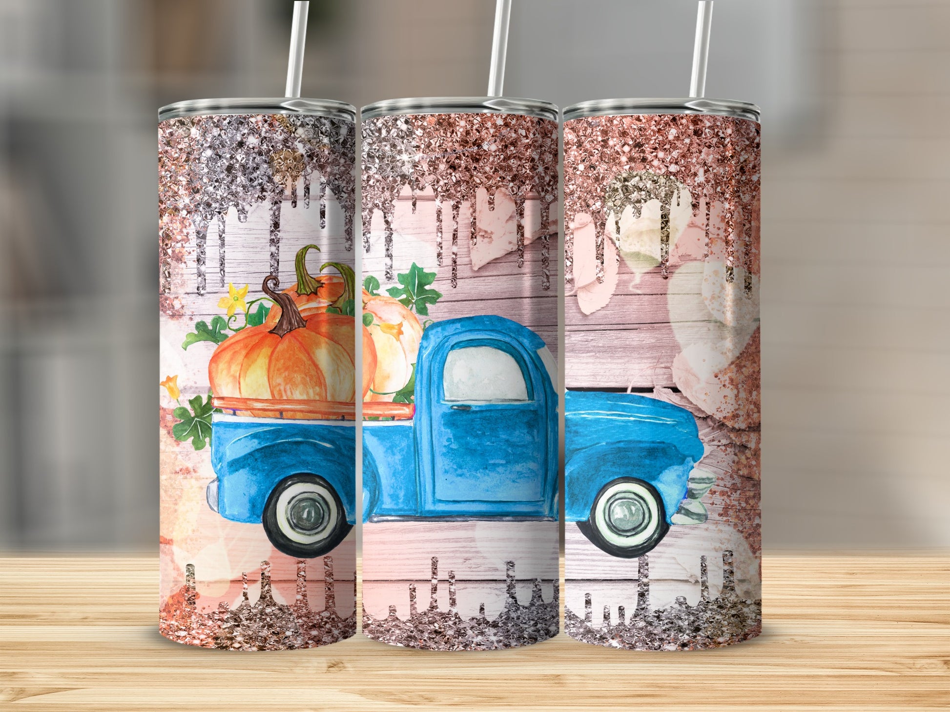Blue vintage truck with pumpkins and glitter on wood background, three tumblers.