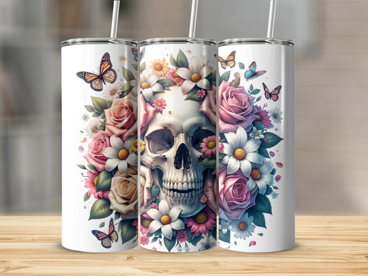 Floral skull tumbler with butterflies and straws on a wooden surface.