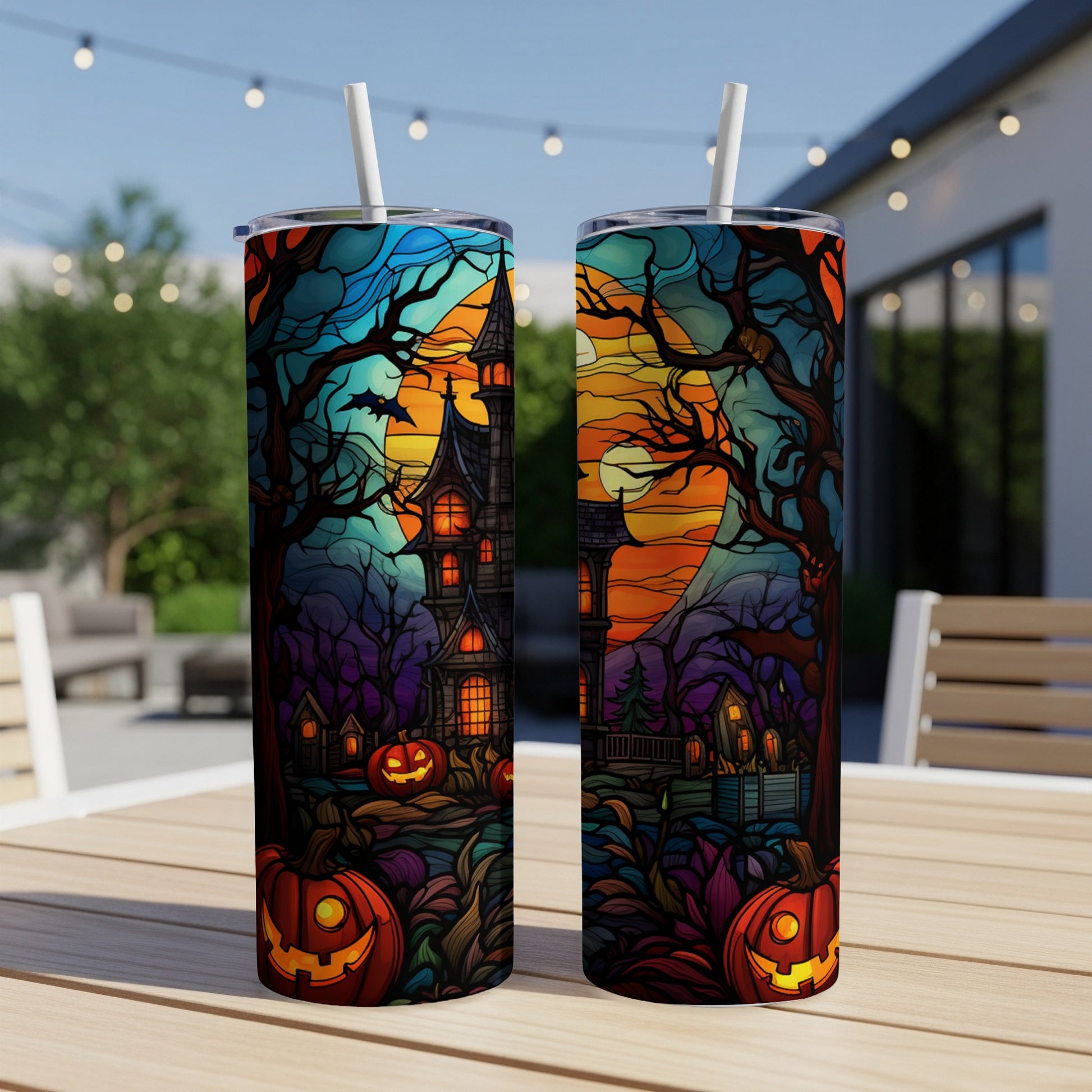 Halloween tumbler with haunted house, pumpkins, and moon illustration.