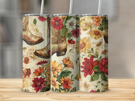 Cowboy boots and floral pattern tumbler on a wooden surface.