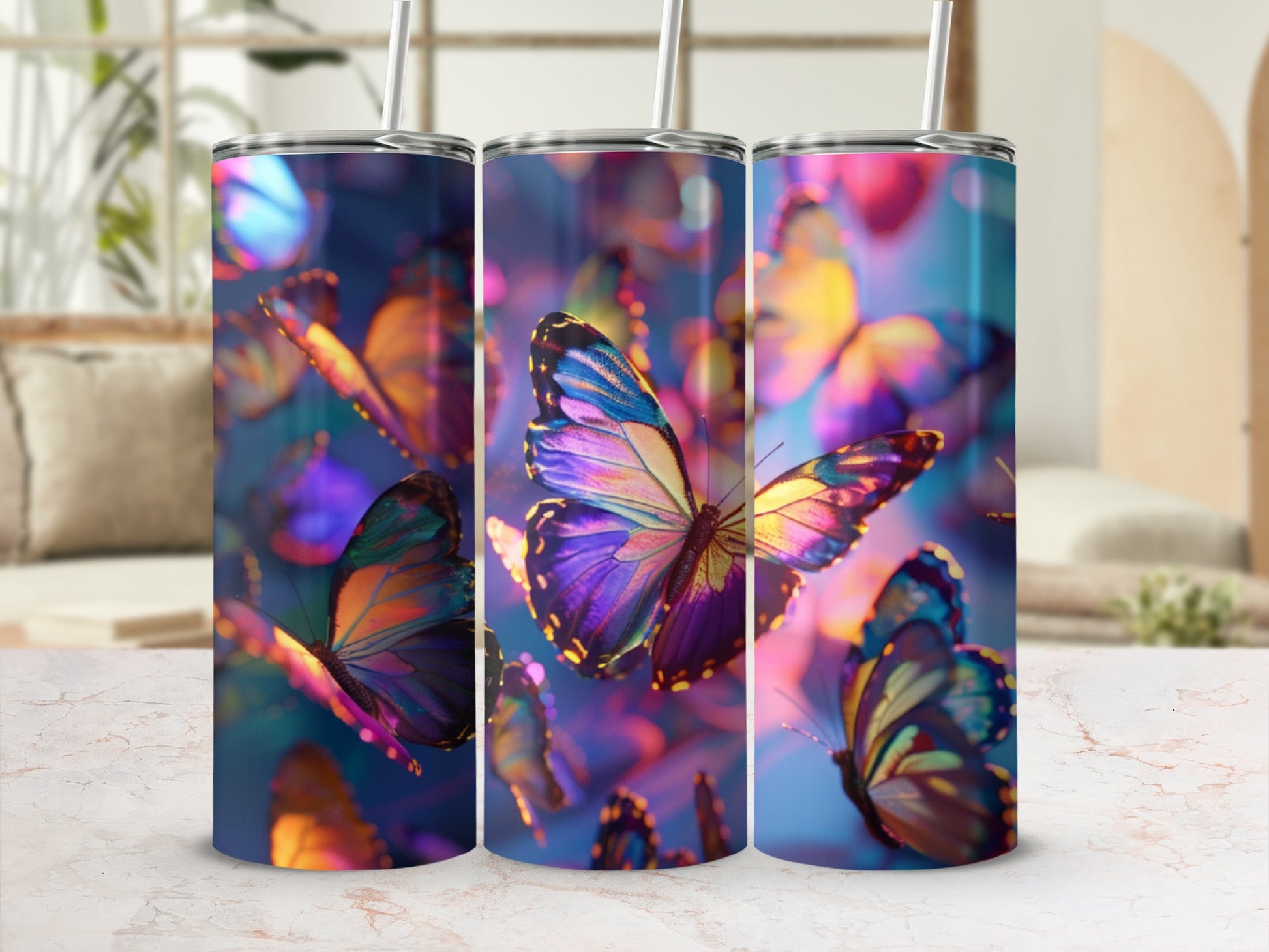 Three tumblers with iridescent butterfly patterns and straws on a marbled surface.