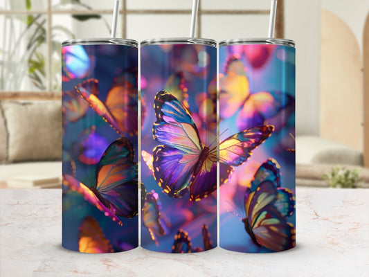 Three tumblers with iridescent butterfly patterns and straws on a marbled surface.