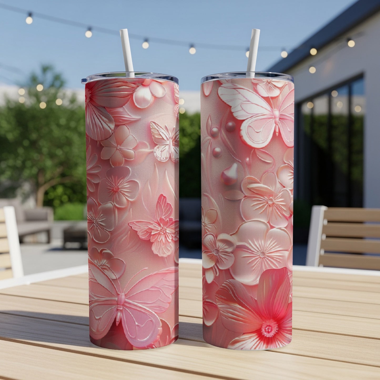 Two pink floral and butterfly patterned tumblers on a wooden table.